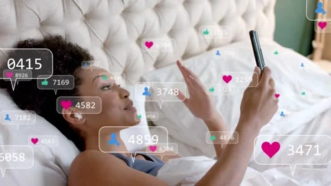 Social media creator lying on bed, speaking into phone, generating heart icons Stock Footage 333397165