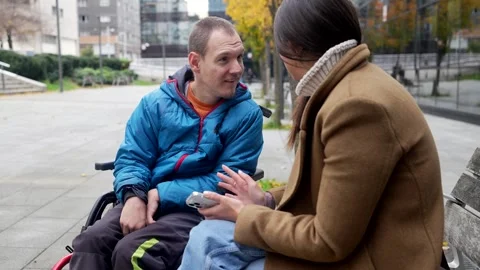 Social worker communicating with a disabled man in a wheelchair Stock Footage 325747738