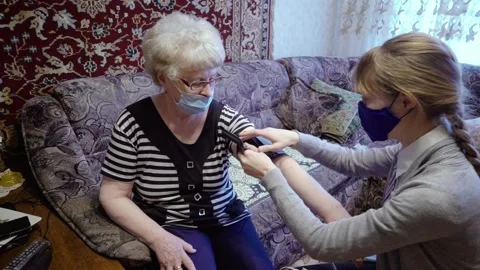 A social worker measures an elderly woman's blood pressure Stock Footage 145180329