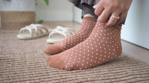 Sock changes in a cozy home setting near a door Stock Footage 325827233