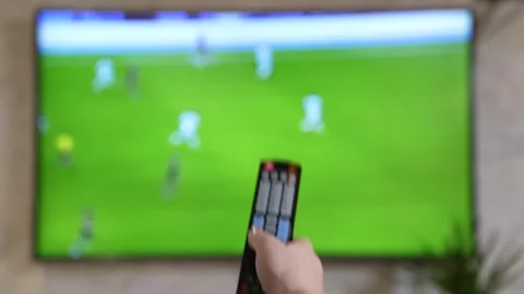 Socker match on TV. Hand with remote control. football Stock Footage 254588727