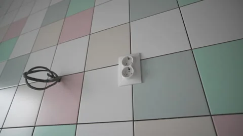 Socket and electric cable on pastel tiled wall in room Stock Footage 312404412