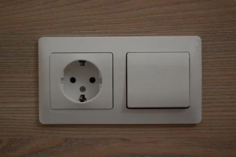 Socket and switch on the same panel on the wall Stock Photos