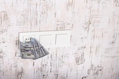 Socket and switch in the wall. 100 is in it. tariff growth. saving electricit Stock Photos