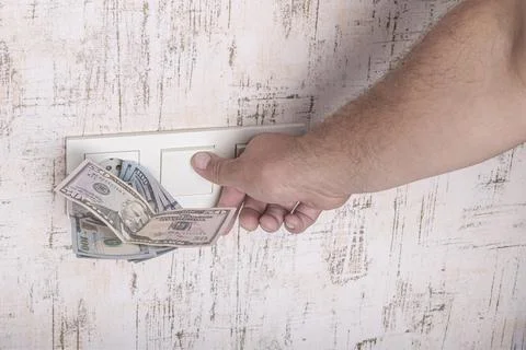 Socket and switch in the wall. 100 is in it. tariff growth. saving electricit Stock Photos