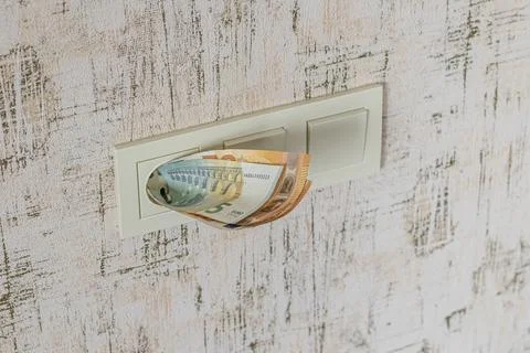 Socket and switch in the wall. the euros are in it. tariff growth. saving ele Stock Photos