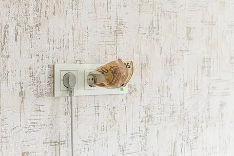 Socket and switch in the wall. the euros are in it. tariff growth. saving ele Stock Photos