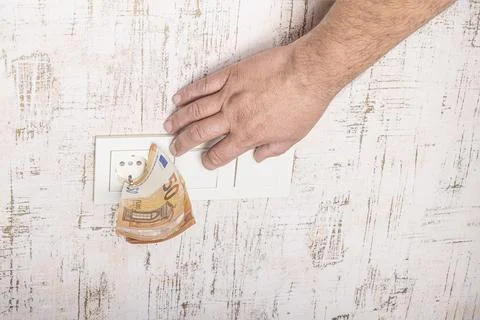 Socket and switch in the wall. the euros are in it. tariff growth. saving ele Stock Photos