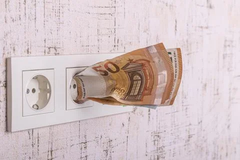 Socket and switch in the wall. the euros are in it. tariff growth. saving ele Stock Photos