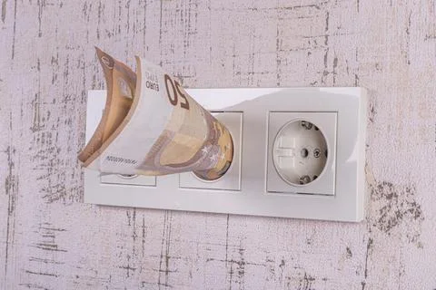 Socket and switch in the wall. the euros are in it. tariff growth. saving ele Stock Photos