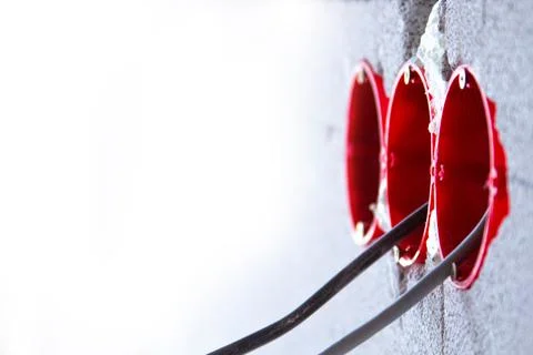 Socket boxes with wires in the wall. Cable routing background. Installation of Stock Photos