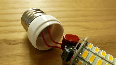 Socket E27 on the LED lamp. Capacitors and soldering board are visible. Stock-Footage 130981399