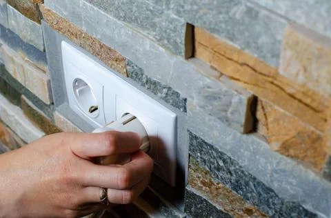A socket with an electric plug in the wall. Energy saving concept. Stock Photos