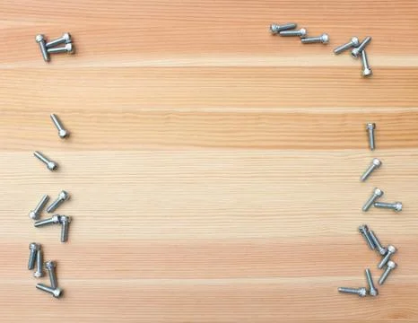 Socket head bolts as border on wood Stock Photos