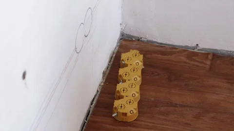 Socket layout marked on wall with yellow junction box on floor Stock Footage 339298356