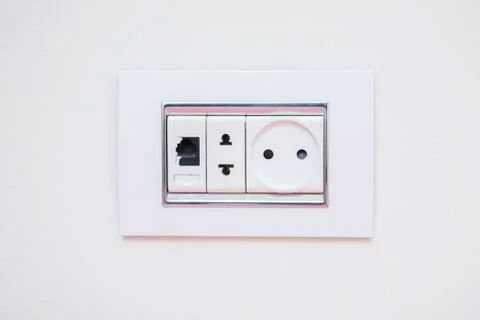 A socket on a light gray wall, a multifunction outlet with an internet connec Stock Photos