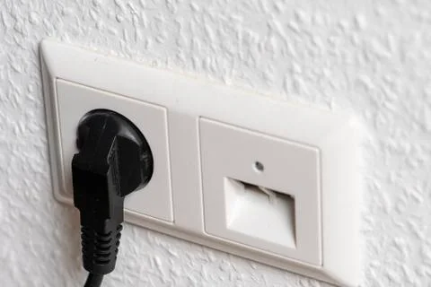 Socket with plug on a wall with data cable socket Stock Photos