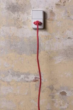 Socket with red wire on grungy wall Stock Photos