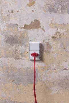 Socket with red wire on grungy wall Stock Photos