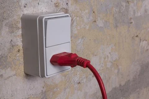 Socket with red wire on grungy wall Stock Photos