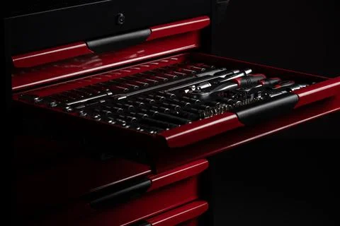 Socket set organized in tool chest drawer in dark workshop Stock Photos