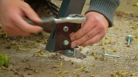 Socket tool rotating fastener into plastic dowel embedded in concrete slab Stock Footage 340197220