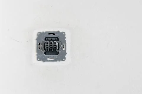 Socket on the white wall, electrical socket without cover. Stock Photos