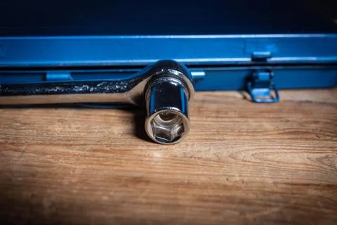 A socket wrench in front of a blue tool box Stock-Fotos