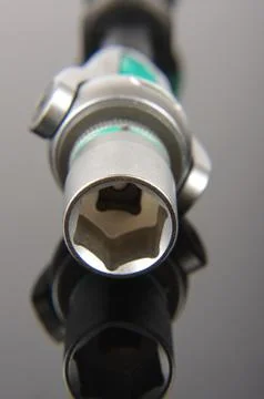 Socket wrench head close up isolated on the black reflective background Stock Photos