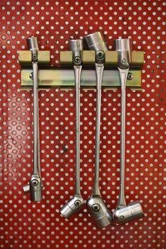 Socket wrenches hanging on red wall. Mechanical tools Stock Photos