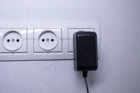 Sockets for electrical appliances on a light gray wall. a multifunction outlet Fotos de archivo