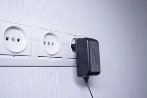 Sockets for electrical appliances on a light gray wall. a multifunction outlet Fotos de archivo