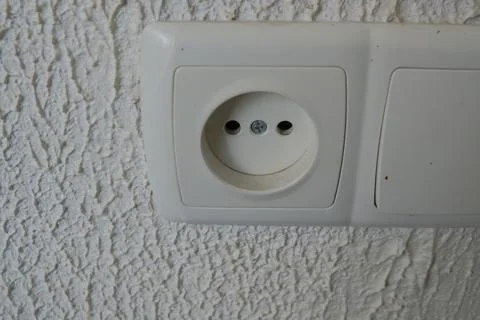 Sockets on the wall, light background, switch nearby, household appliances Stock Photos