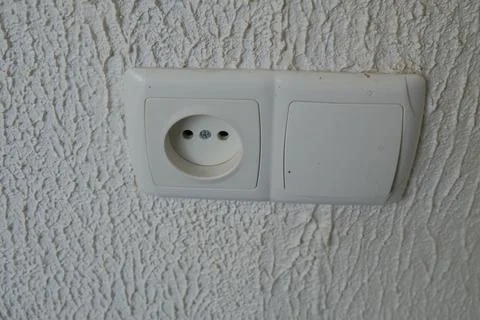 Sockets on the wall, light background, switch nearby, household appliances Stock Photos