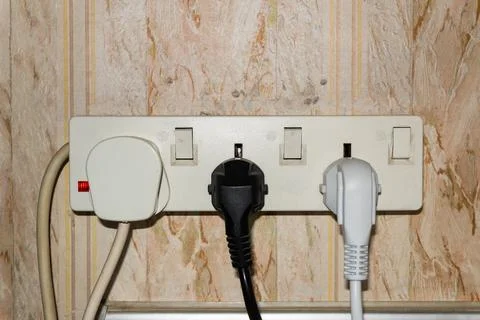Sockets in the wall, wires in the socket on the kitchen wall, overloaded wall Foto stock