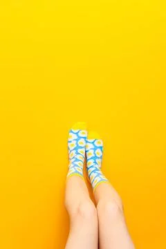 Socks with fried egg pattern on yellow background with copy space. Vertical.. Foto stock