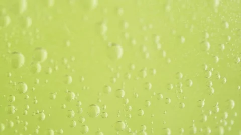 Soda bubbles in water on yellow background. Bubbles rising to surface. Stock Footage 267983010