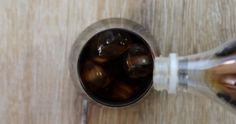 Soda (cola) being poured into plain glass with ice UHD 4K Video Stock Footage 101436258