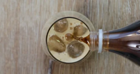 Soda (cola) being poured into plain glass with ice UHD 4K Video Stock Footage 101443493