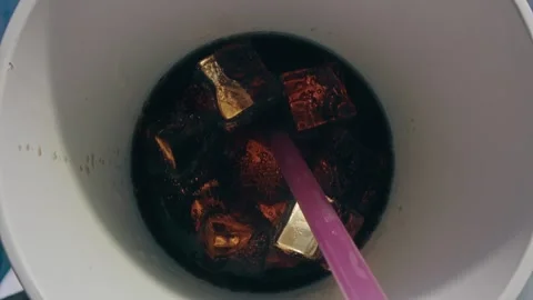 Soda Drink Served in a Cup with Ice Cubes and a Plastic Straw Stockbeeldmateriaal 331098950