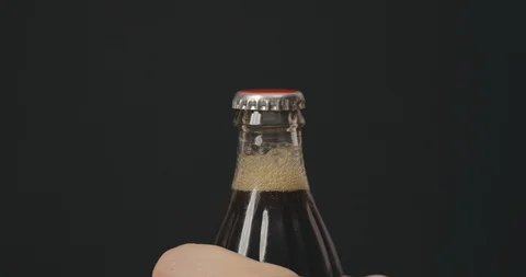 Soda glass bottle being opened by opener. Man's hands open fizzing refreshing Stock Footage 123764284