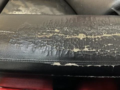 Sofa armrest with peeling and cracked surface Stock Photos