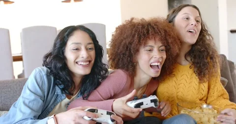 On sofa female friends pressing button starting game grabbing controllers and Stock Footage 344325872