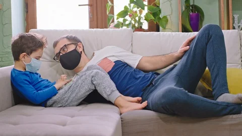 On the sofa at home dad with his small son spending time together wearing Stock Footage 127713375