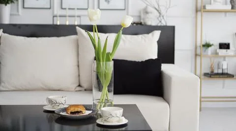 Sofa in a modern interior. On the table are a bouquet of tulips Stock Photos