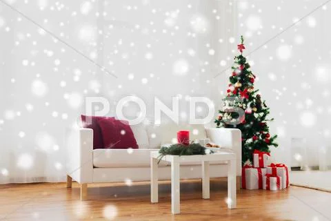 Sofa, table and christmas tree with gifts at home Stock Photos
