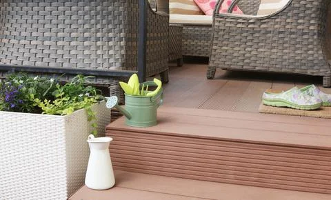 Sofa on terrace. Steps to patio. Backyard and flowers. Tools in garden. Summer Photos