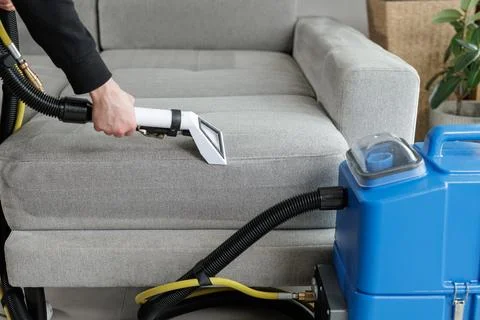 Sofa upholstery cleaning with extraction machine removing dirt from fabric .. Stock Photos