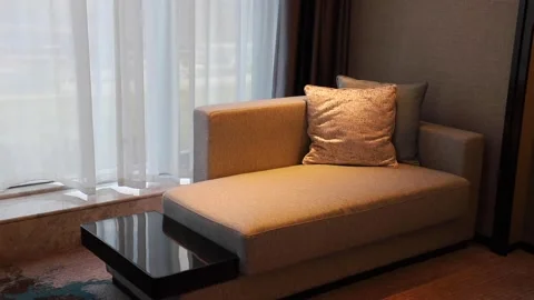 Sofas near a window with waving curtain in a hotel room Stock Footage 136522499