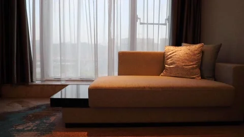 Sofas near a window with waving curtain in a hotel room Stock Footage 136522508
